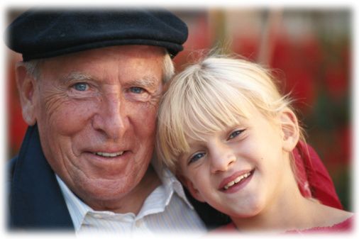 Grandfather with granddaughter (6-7) smiling, portrait